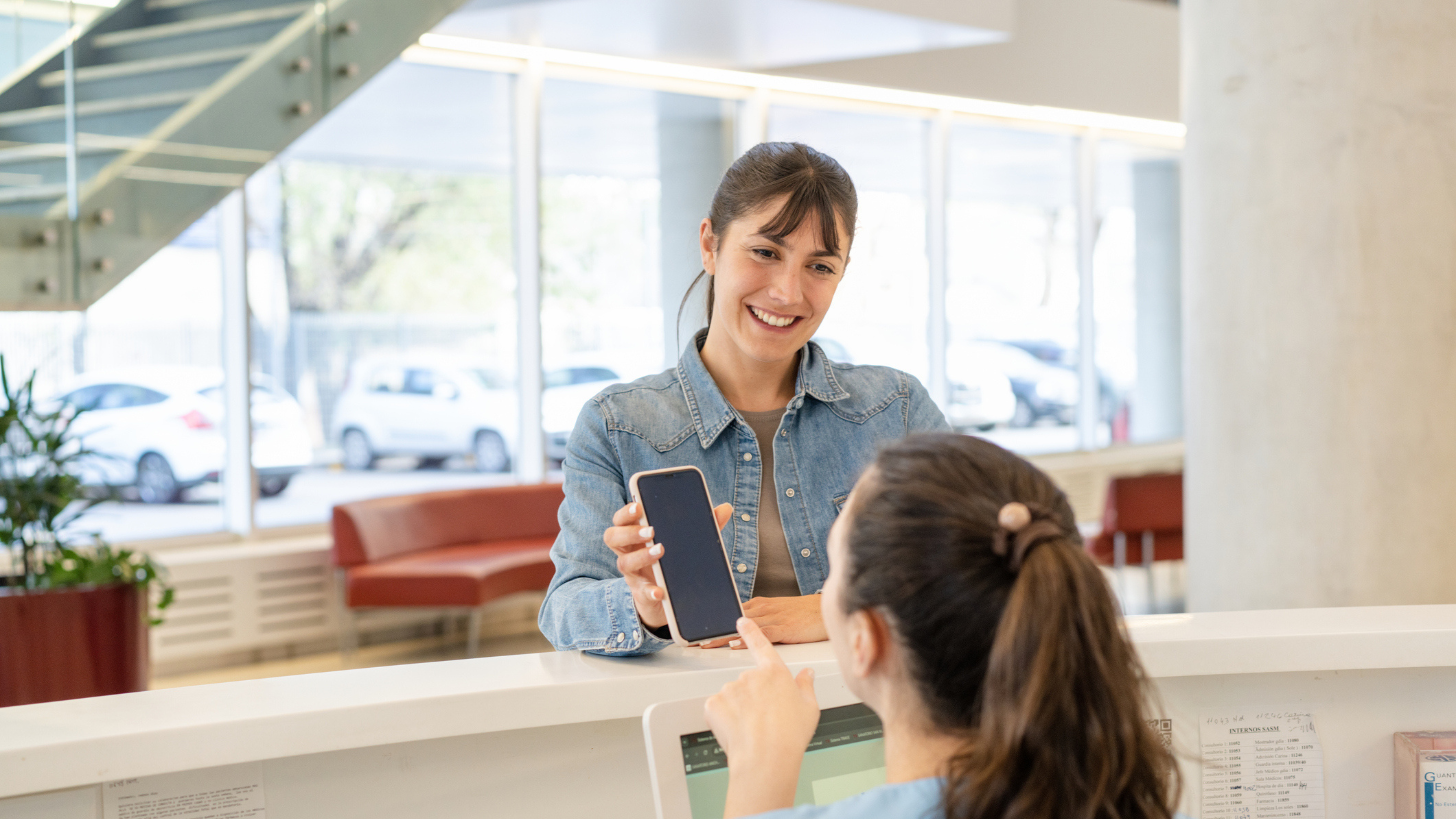 Patient reviewing PatientFi financing options on her phone with help from a provider